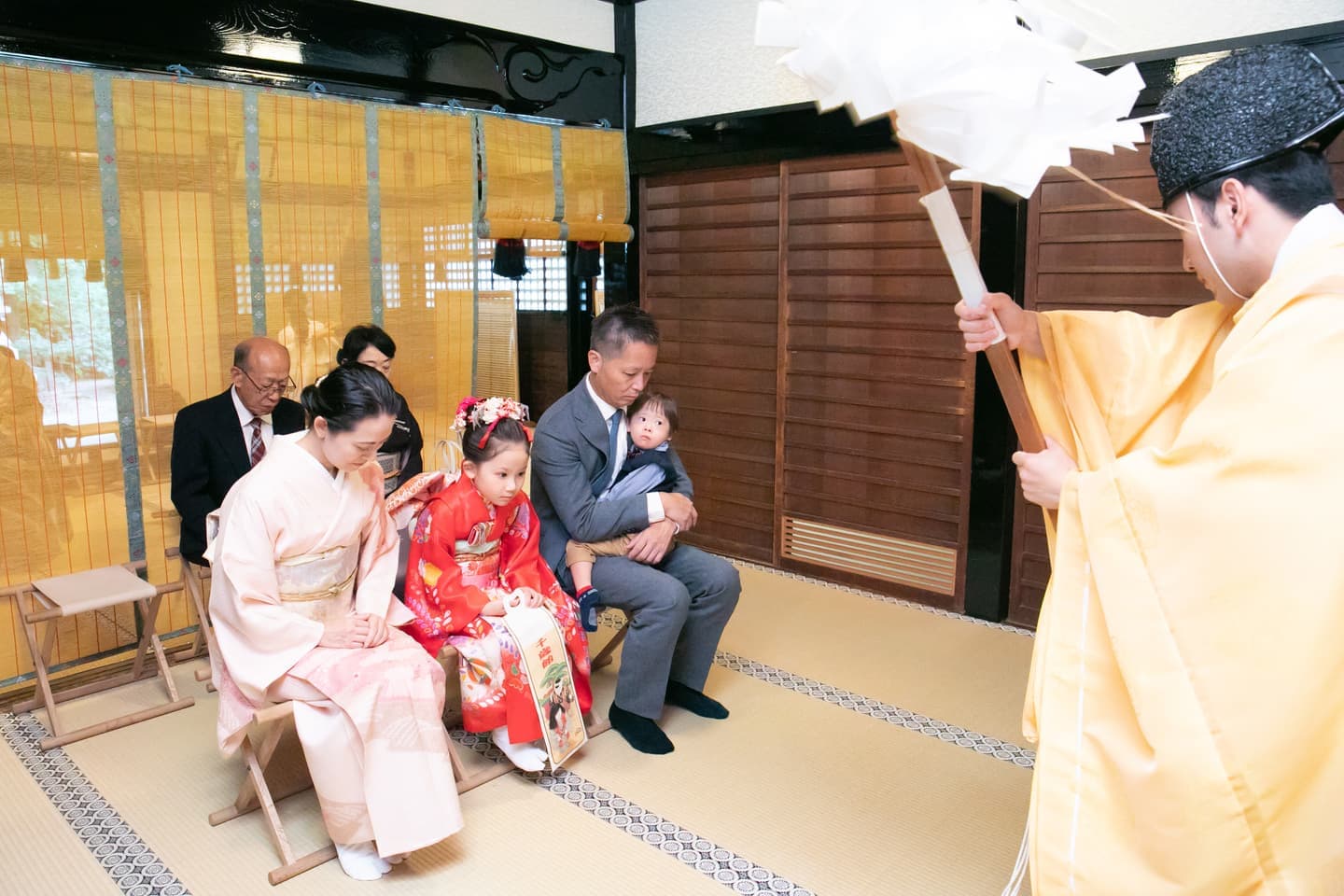 代々木八幡宮の拝殿で七五三の御祈祷を受けるご家族の写真
