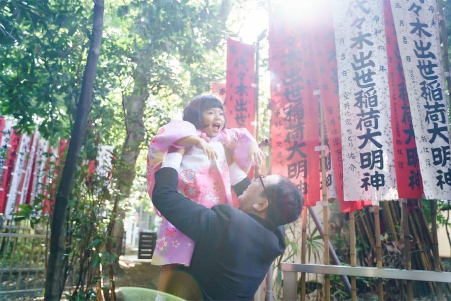 代々木八幡宮での七五三撮影の風景。パパが３歳の女の子を高い高いしている写真