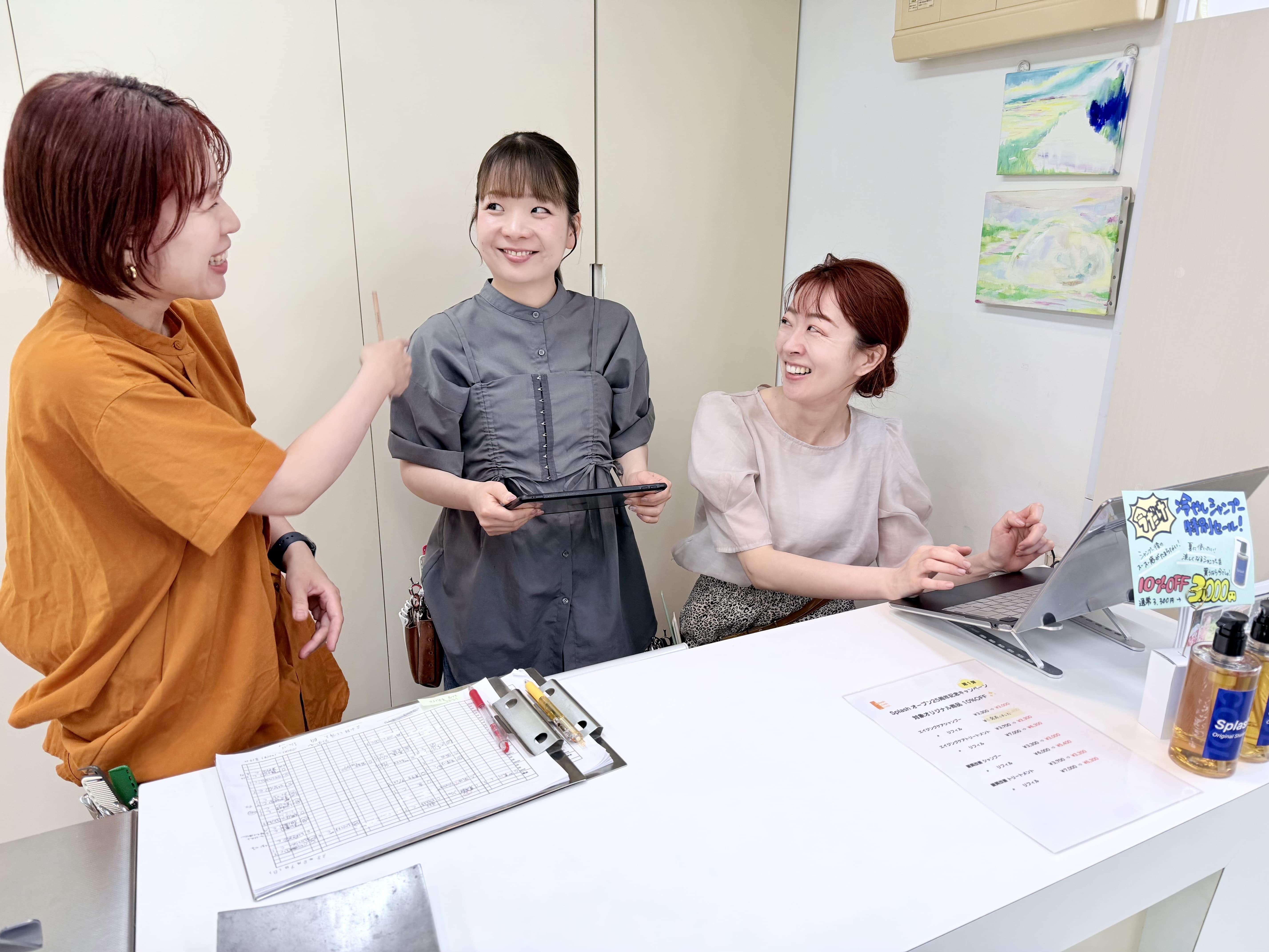 代々木八幡・美容室スプラッシュのフロントで予約について相談しているスタッフの写真